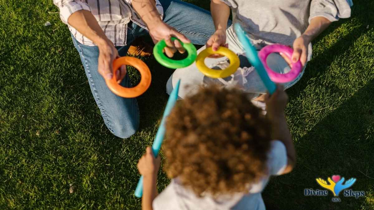 child-and-adults-taking-turns-with-ring-toss-on-grass