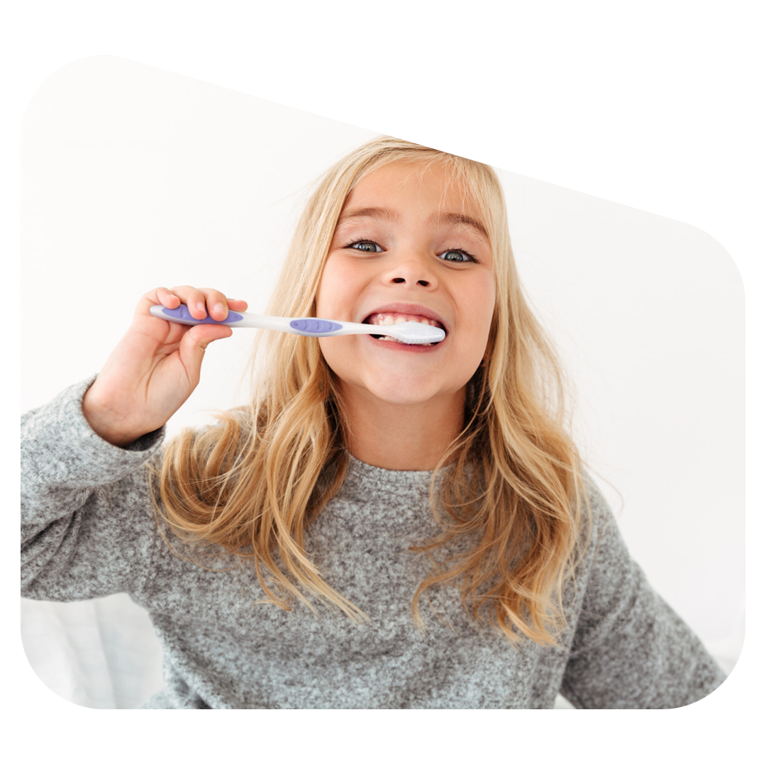 Girl brushing teeth with a purple toothbrush.