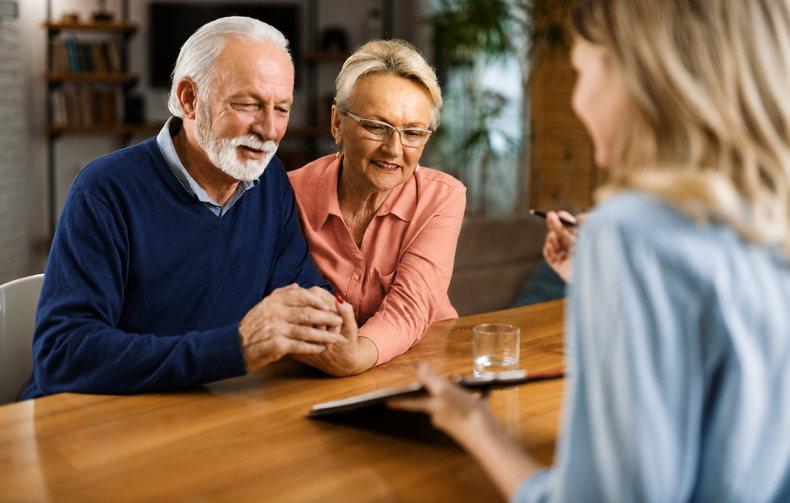 Two people chatting across a table with a therapist in a counseling office