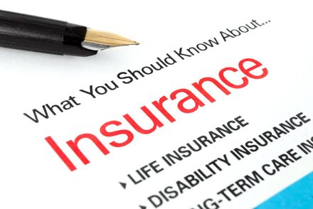 Insurance brochure with red title and a black pen on white paper