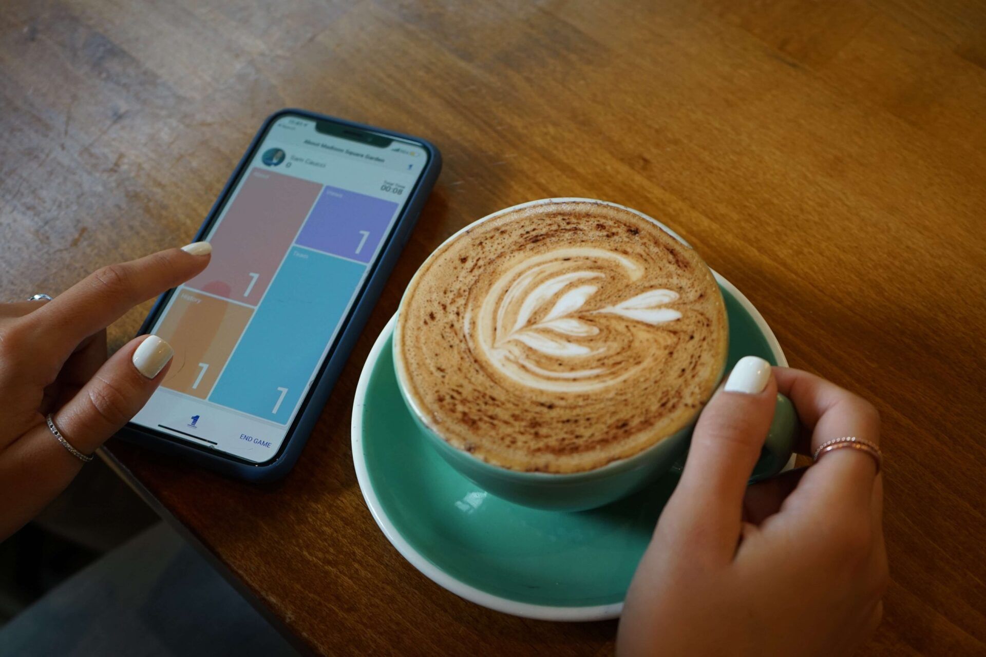 working on mobile app with coffee in hand