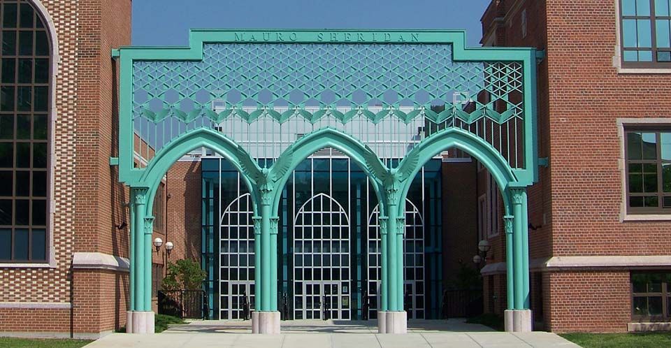 A brick building with a green archway leading to it