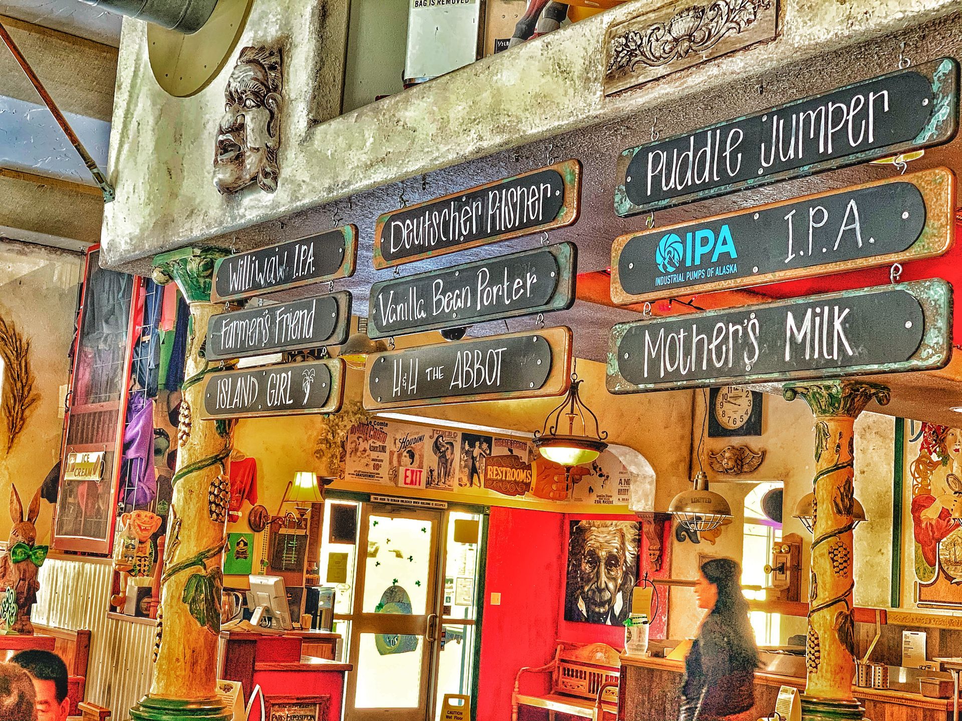 A restaurant with a lot of signs on the wall including one that says mothers milk