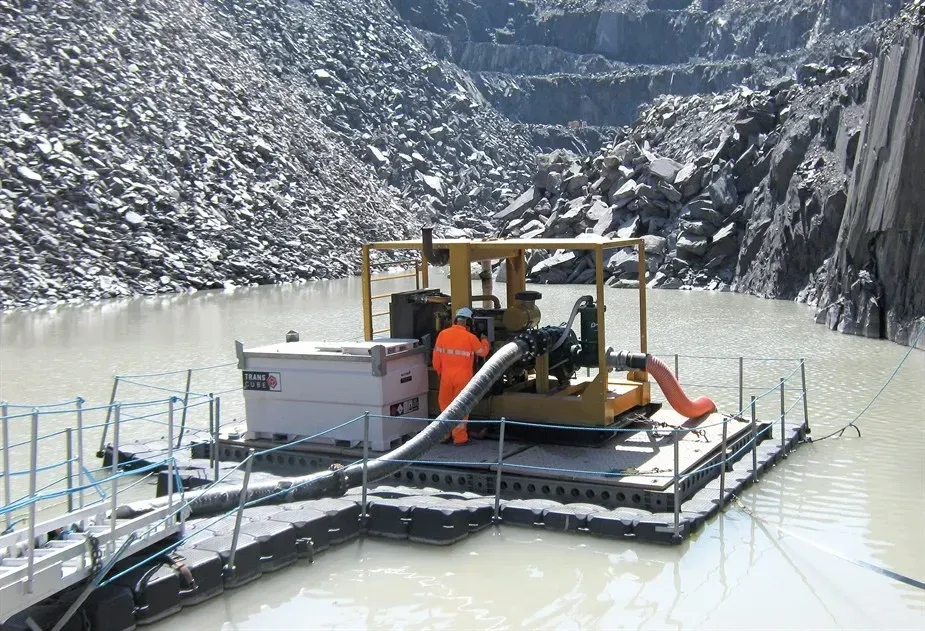 A man is standing on a floating platform in the water