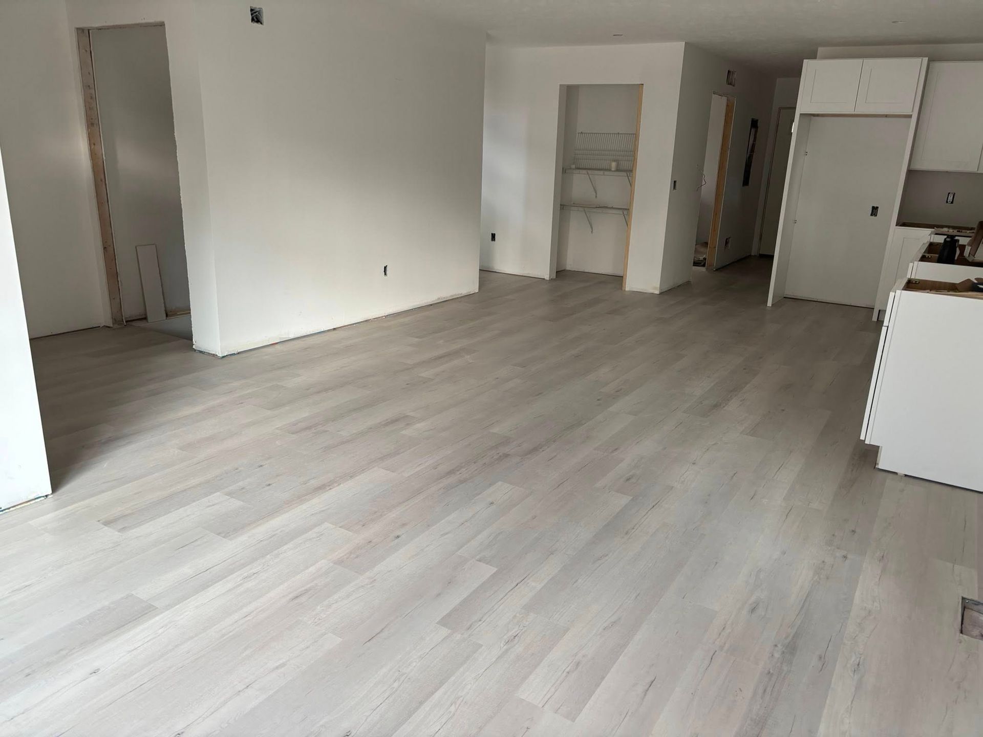 Empty unfurnished room with light wood floors, white walls, and open doorways