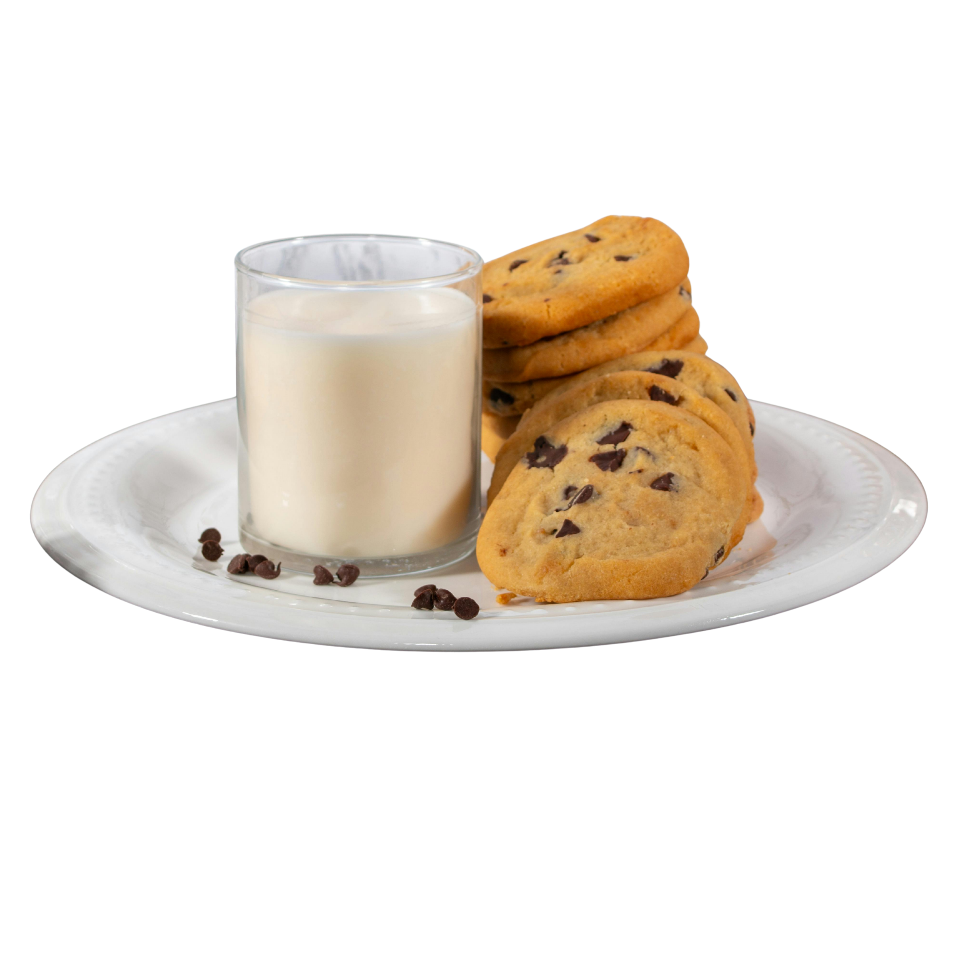 Plate with chocolate chip cookies, a glass of milk, and scattered chocolate chips