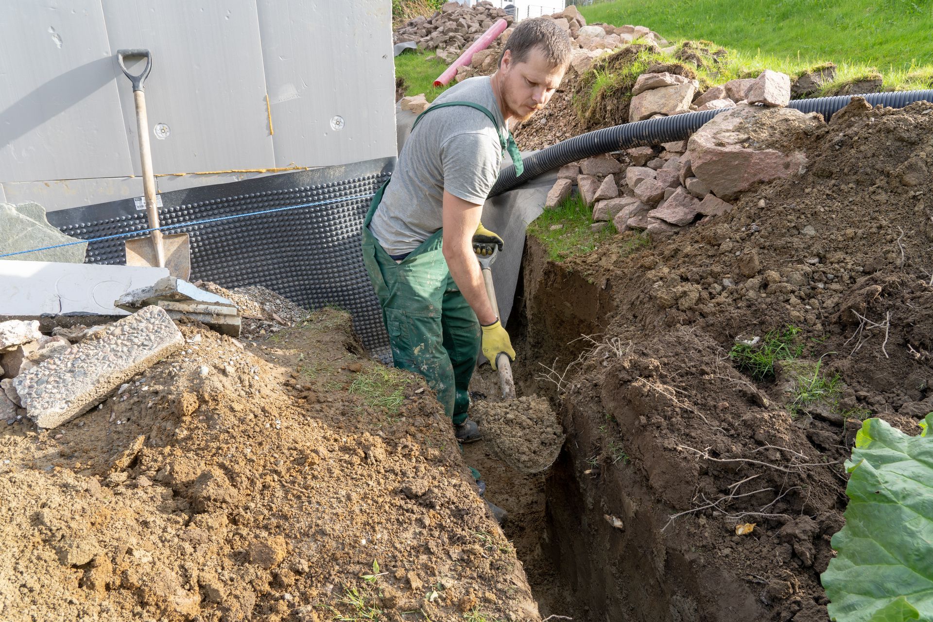 Worker digging a trench to repair a drainage pipe. Worker digging a trench to repair a drainage pipe.