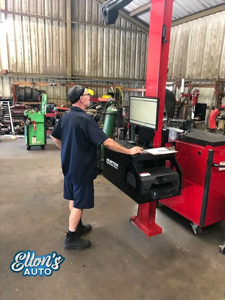 Our expert technician Robert working on computer in our garage for wheel alignment | Elton's Auto