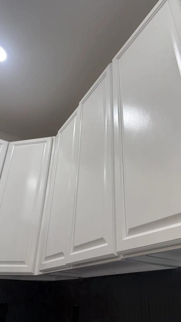 White kitchen cabinets with crown molding along the ceiling, viewed from below.