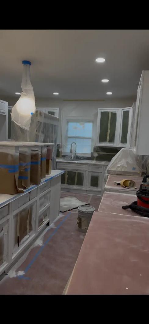 Kitchen under renovation with cabinets, covered counters, and recessed ceiling lights