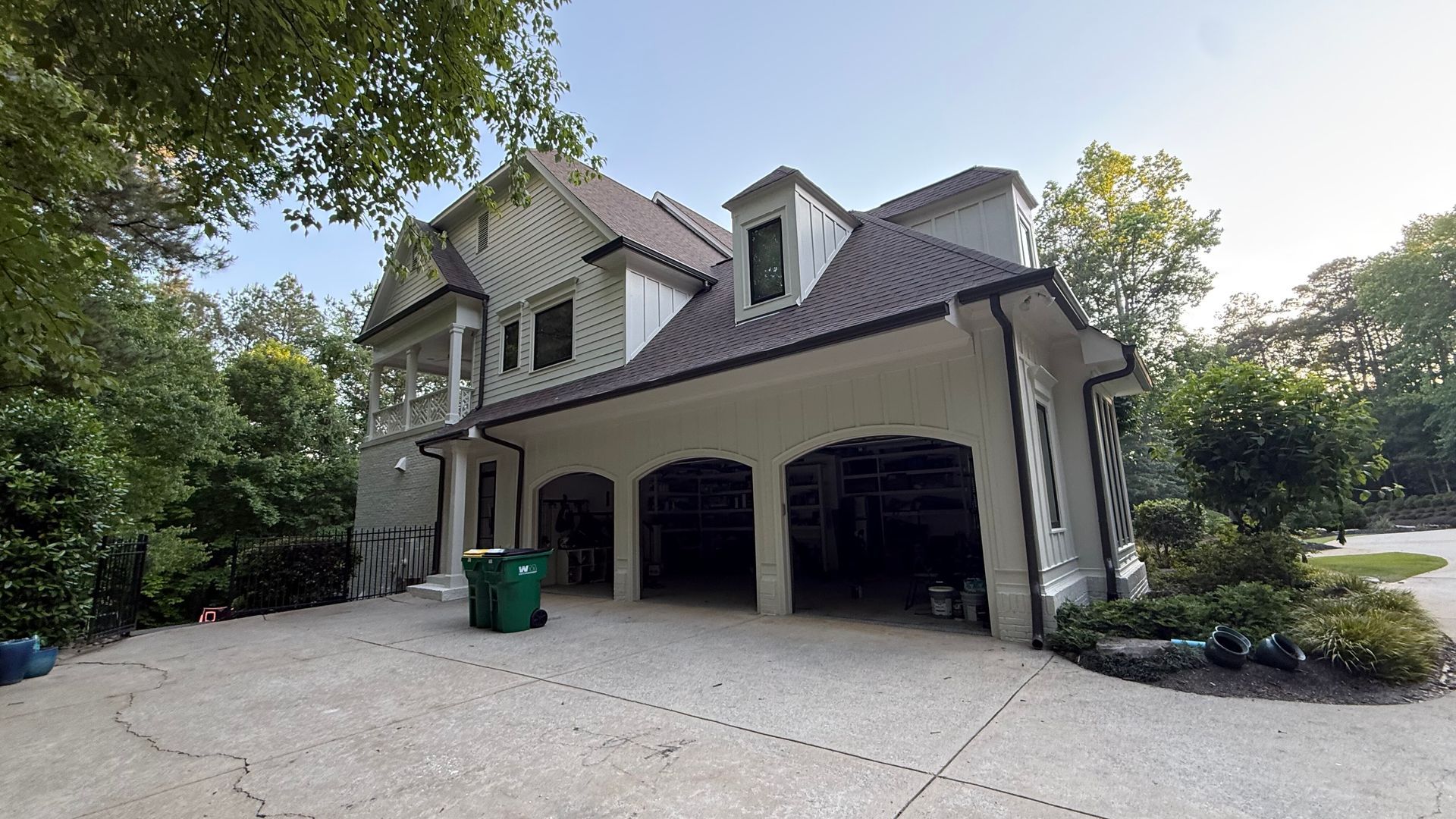 Suburban house with a three-car garage, driveway, and trees in front yard