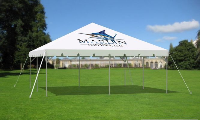 White tent on green grass with a blue marlin logo