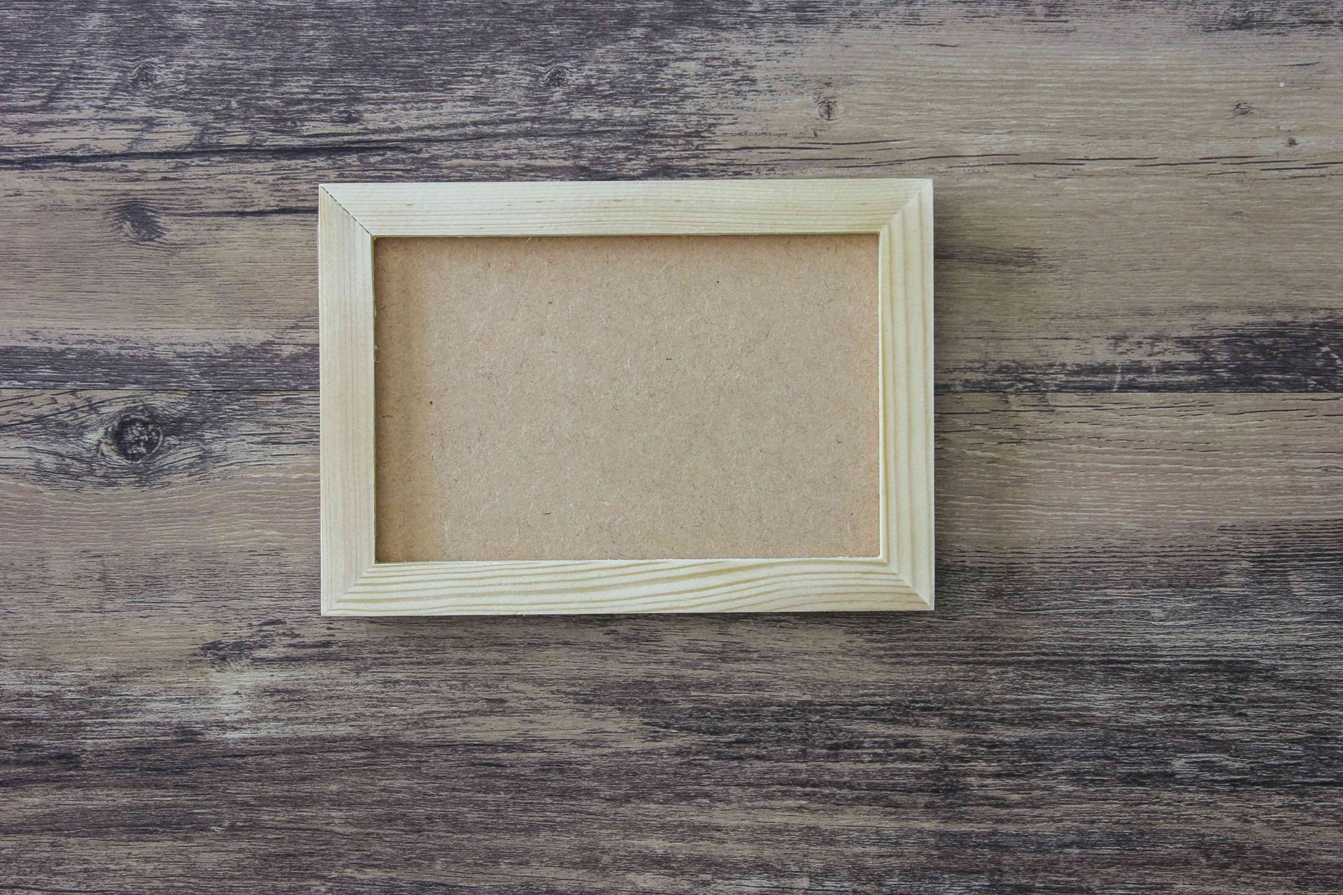 Small empty wooden frame on a rustic gray wood background