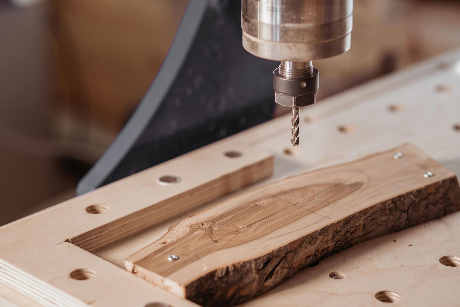 CNC router cutting a wooden slab in a workshop