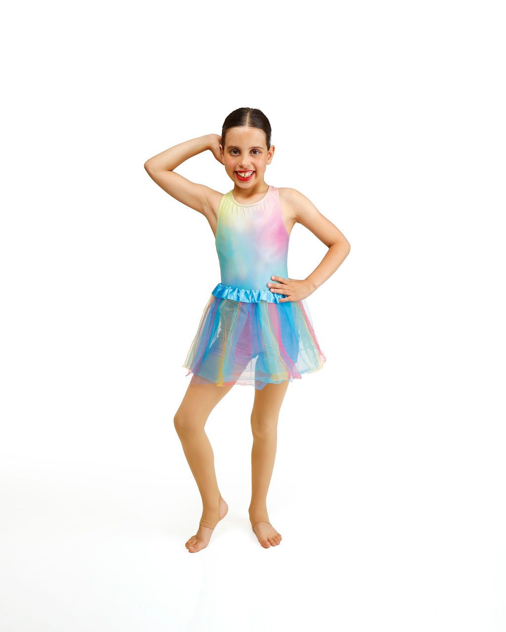 Girl in a rainbow tutu posing with one hand on her hip and one hand behind her head.