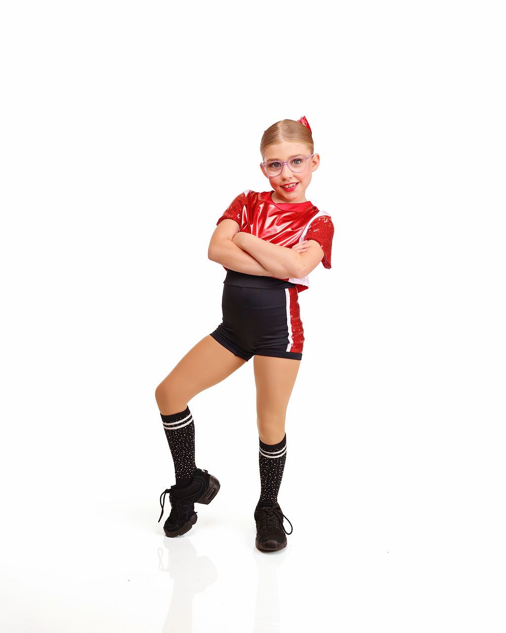 Person in a red shirt and black skirt posing with arms crossed against a white background.