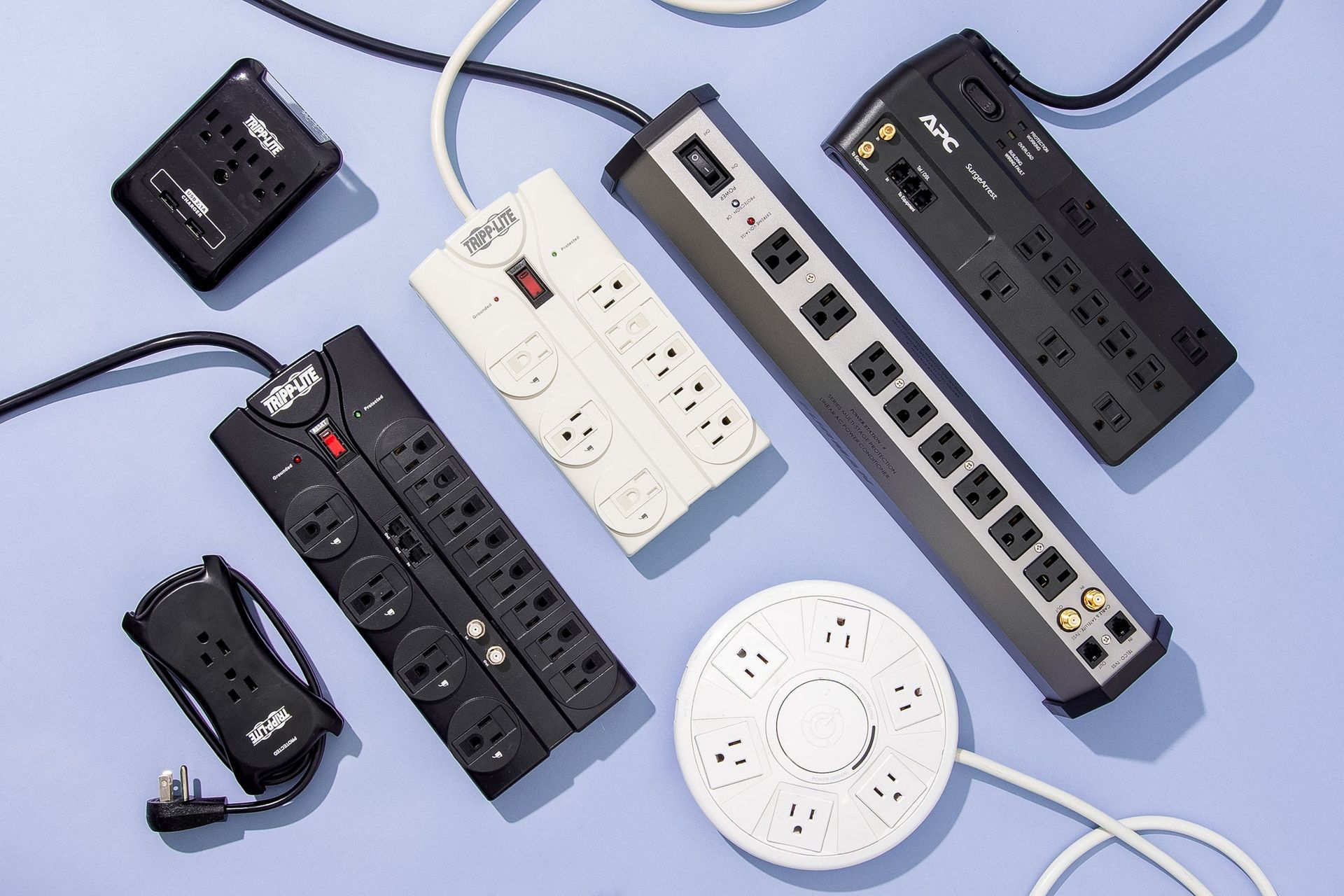 A bunch of power strips are sitting on top of each other on a table.