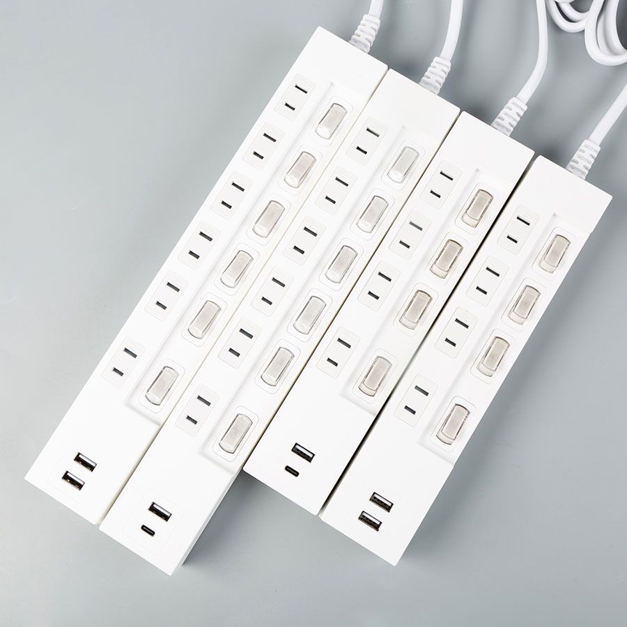 Three power strips are stacked on top of each other on a table.