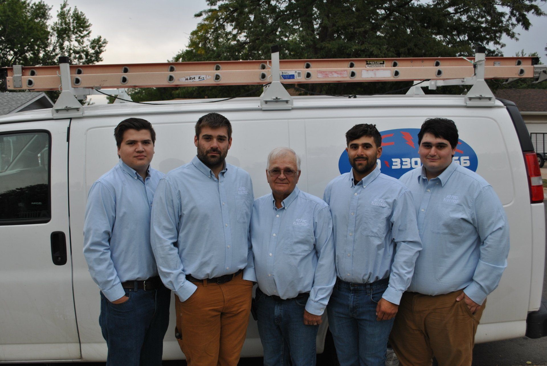 A group of men standing in front of a van that says dee on it