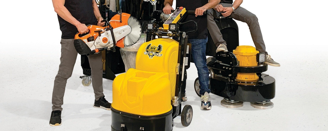 People using yellow and black floor scrubber machines in a studio setting