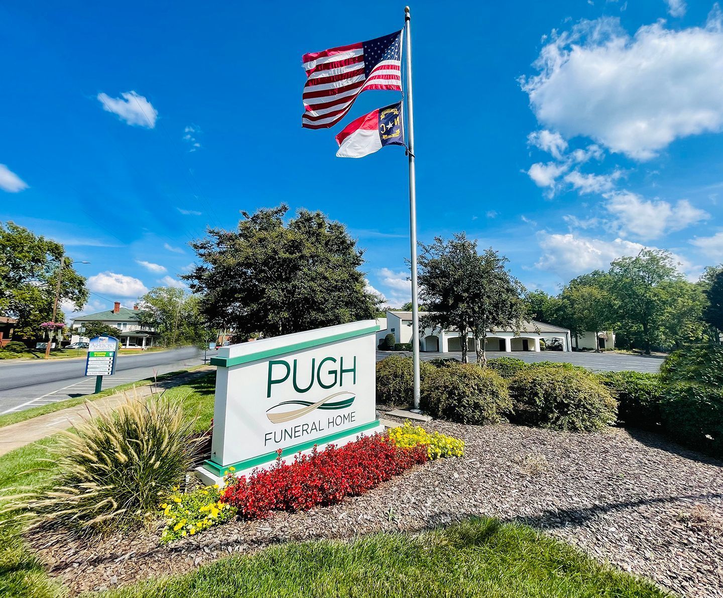Pugh Healthcare sign by roadside with U.S. and Florida flags on a sunny day