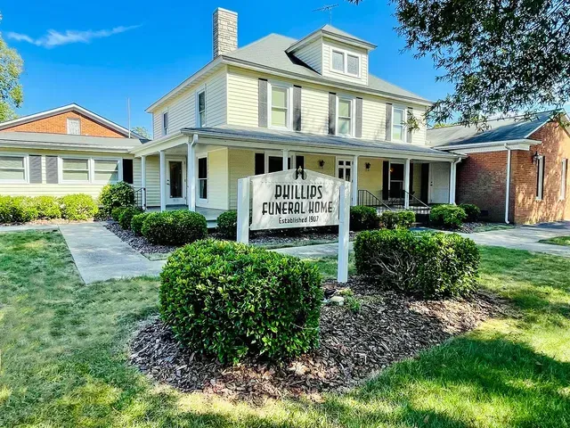 A light yellow house with a white porch and sign reading “Drumm’s Family Law” in front.