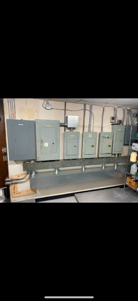 Electrical panels mounted on a wall. Metal boxes with conduit.