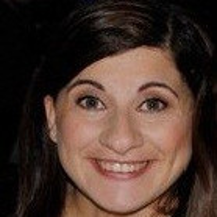A close up of a woman 's face smiling.