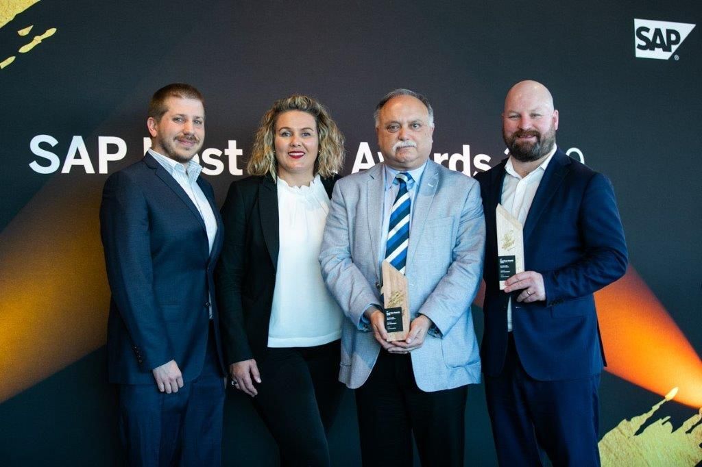 A group of people standing next to each other holding awards.