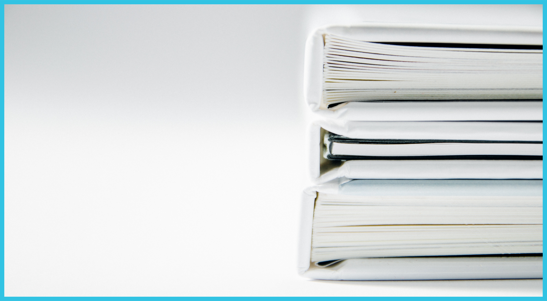 Three binders are stacked on top of each other on a white surface.