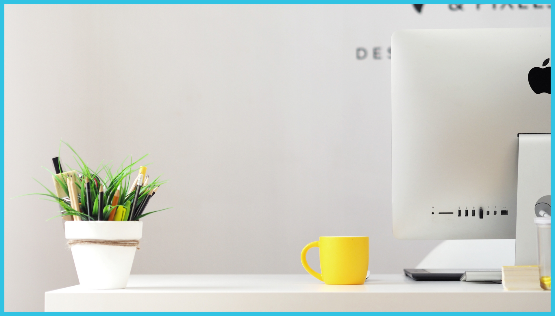 A desk with a computer and a yellow cup on it