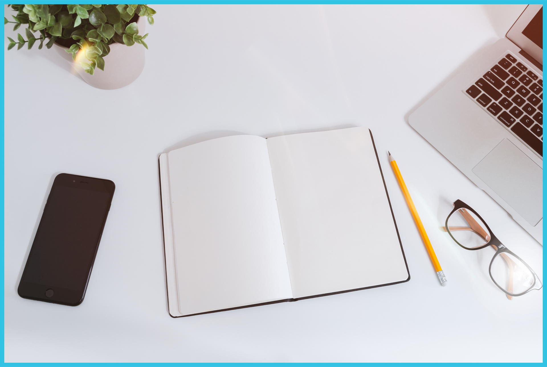 A notebook a pencil a cell phone and a laptop are on a desk
