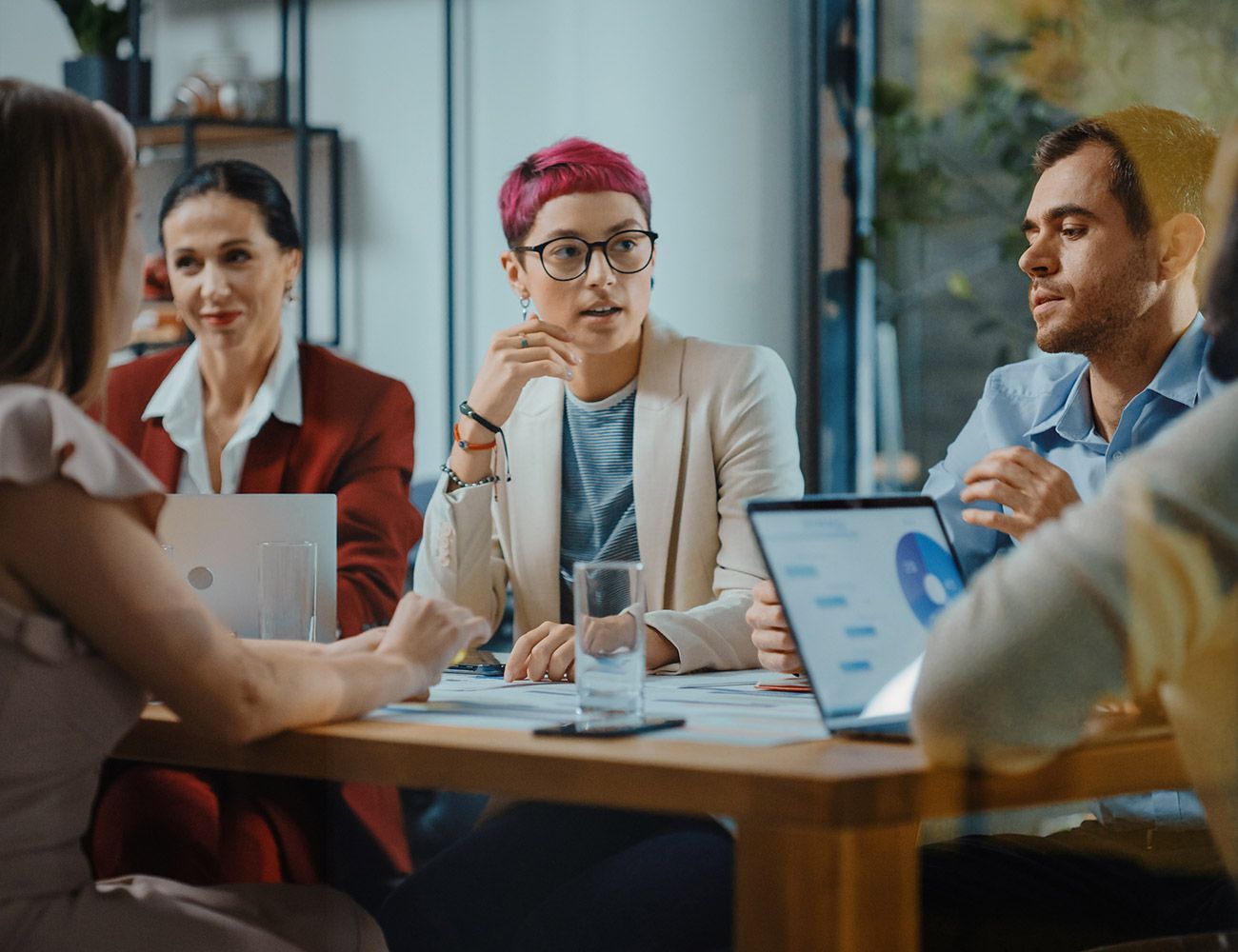A group of people are sitting around a table having a meeting.