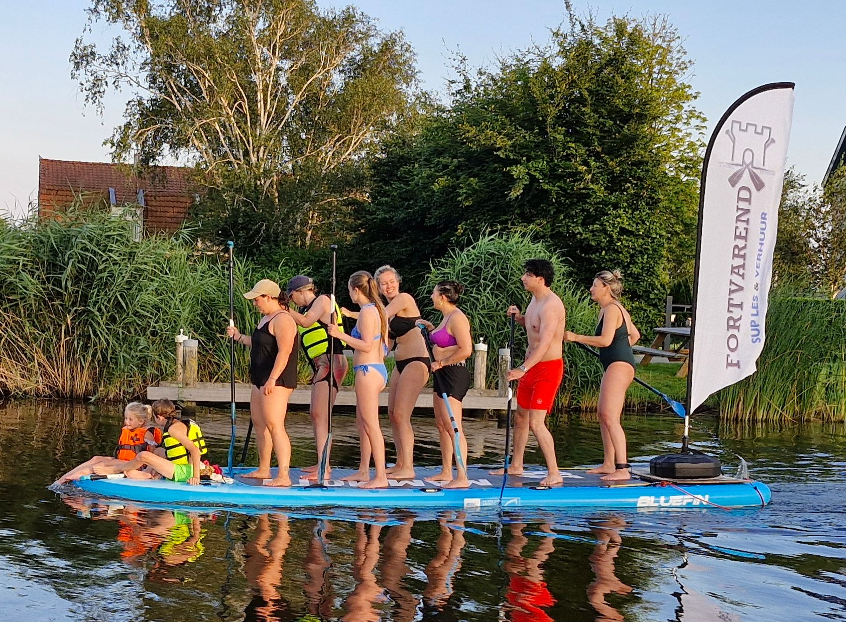 een groep personen varen op een big sup