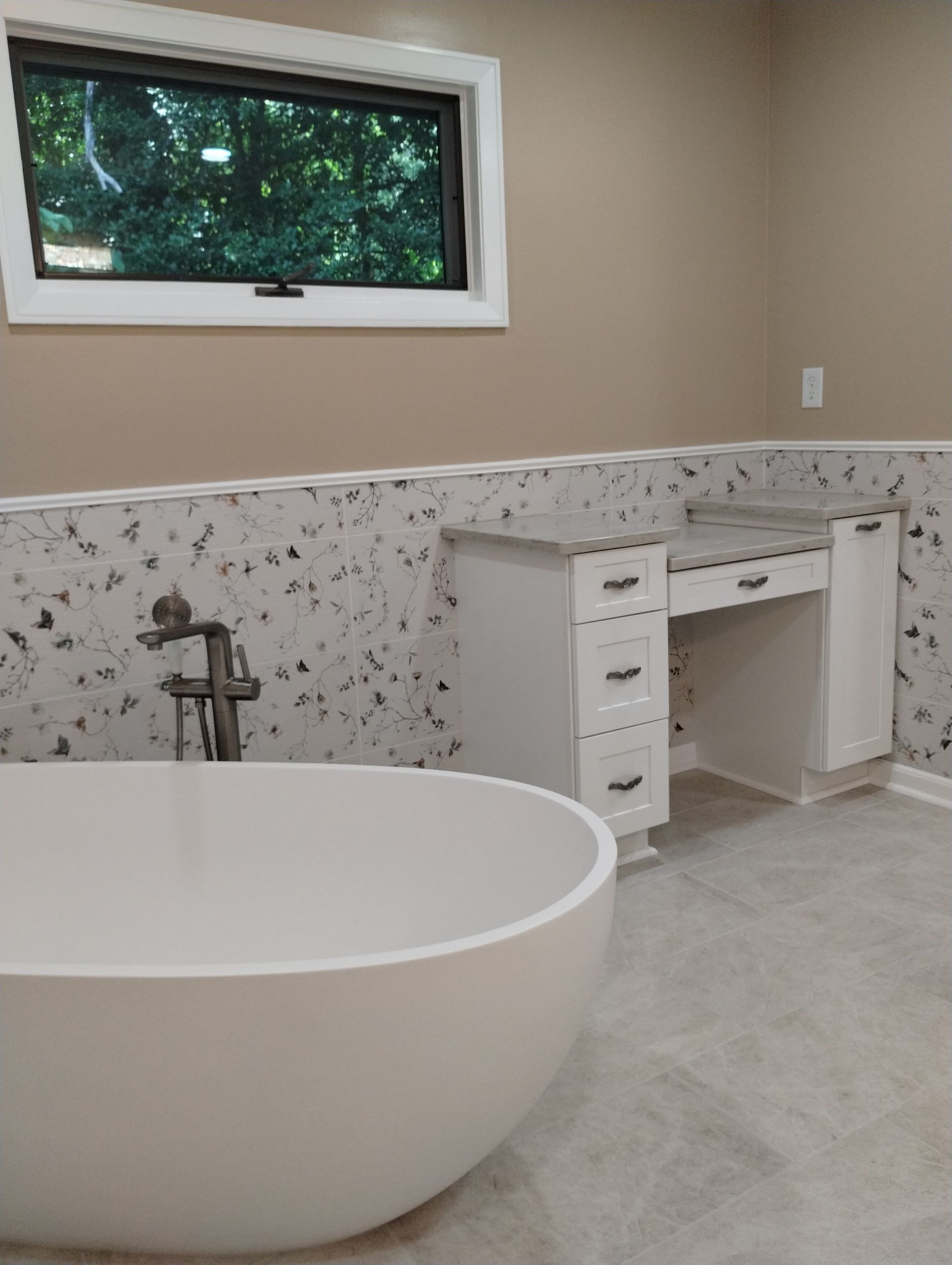 Modern bathroom with freestanding tub, double vanity, and speckled marble tile wall