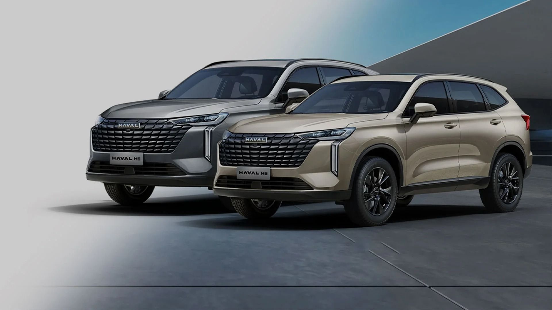 Dos SUV de color beige exhibidos uno al lado del otro en el suelo de un estudio con un fondo azul grisáceo.