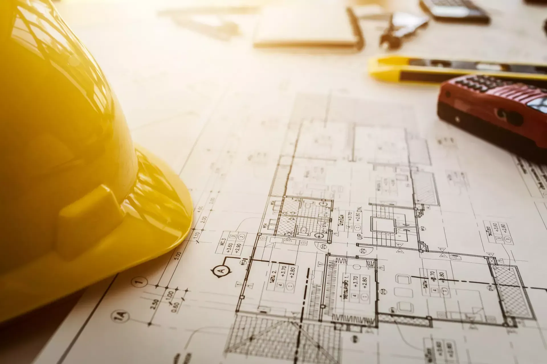 A hard hat is sitting on top of a blueprint.