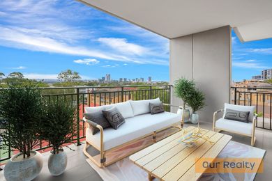 A balcony with a couch and a table with a view of a city.