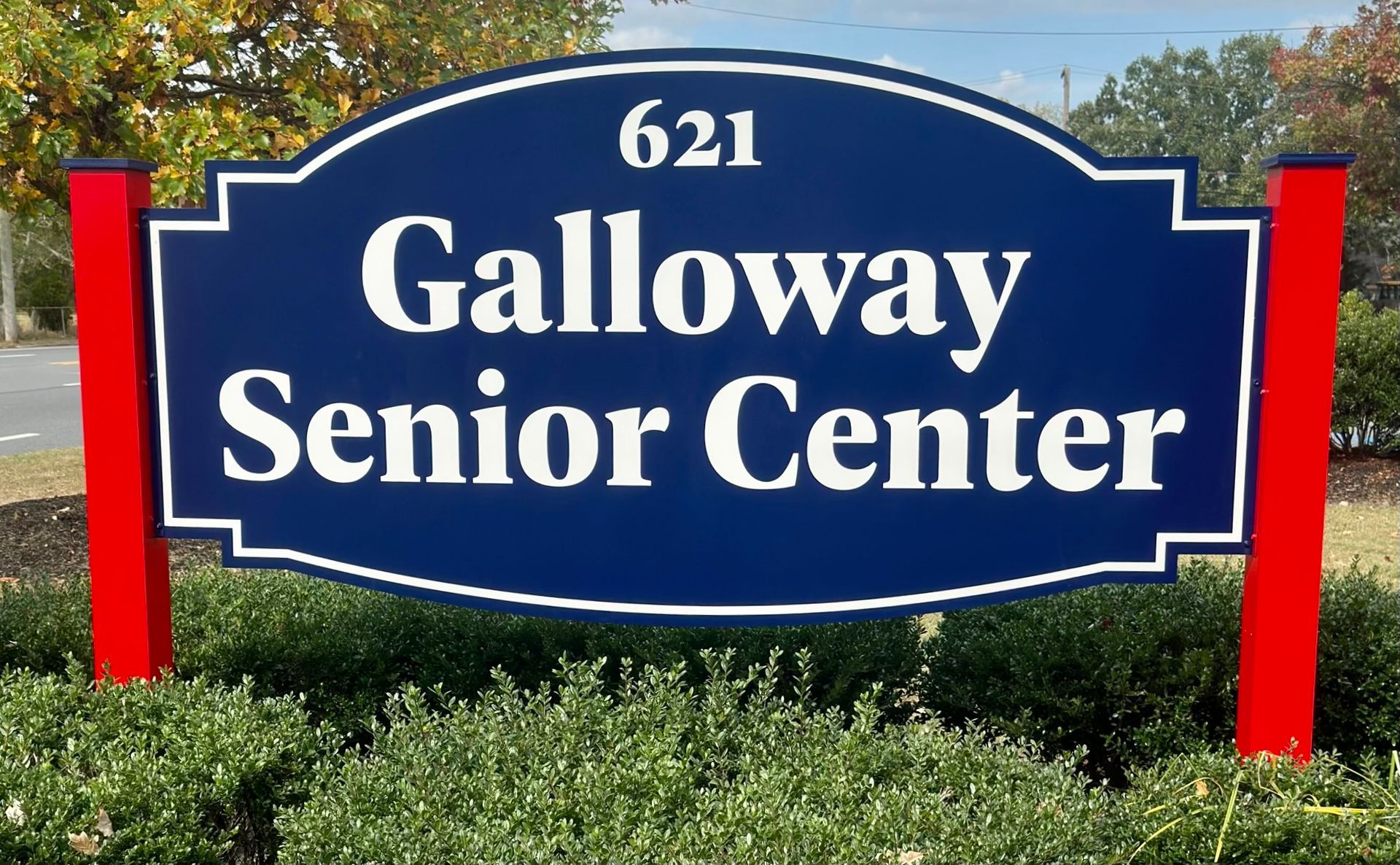 Sign for Galloway Senior Center, navy blue with white trim, red posts, and address 621.