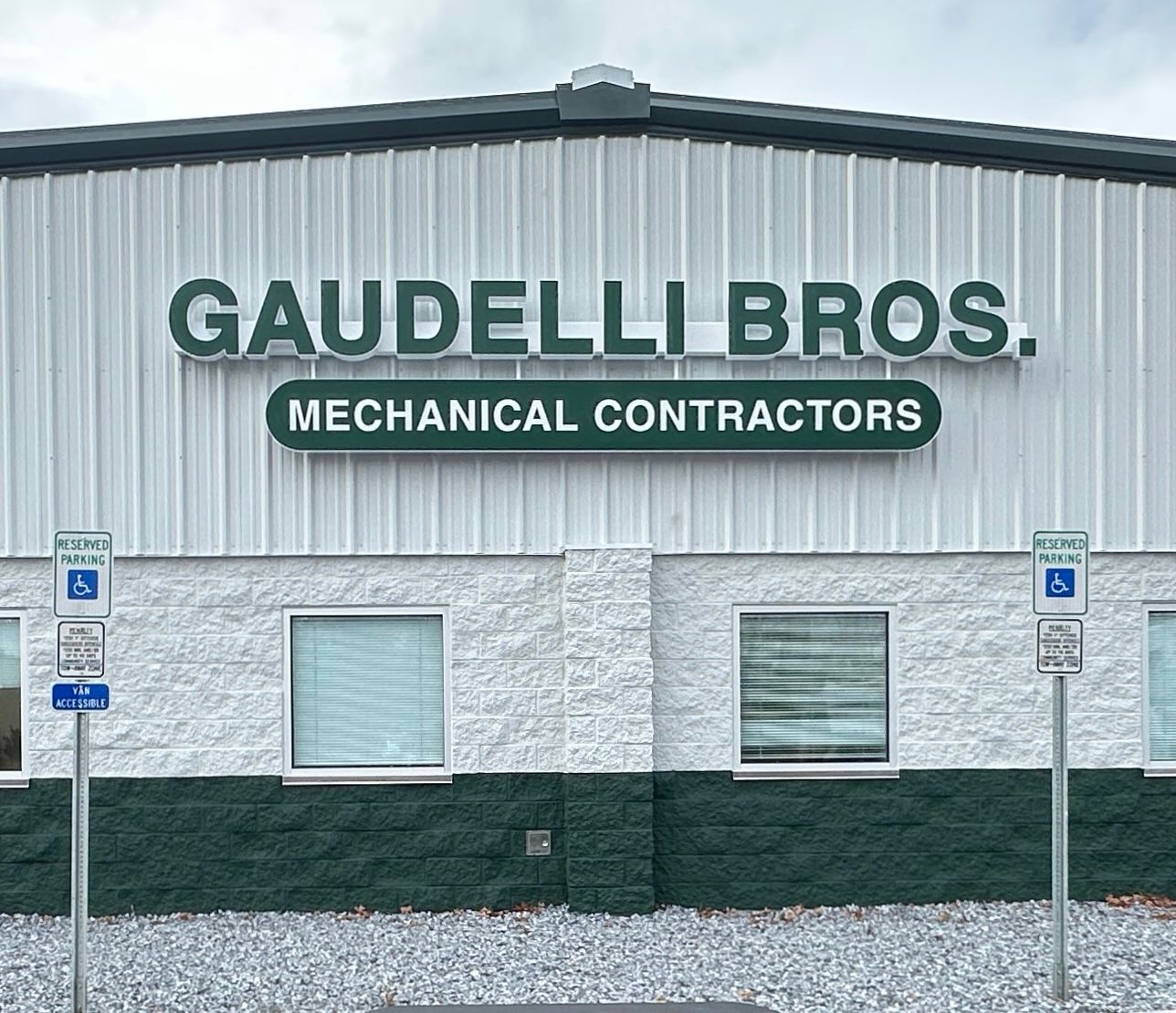 Gaudelli Bros. building exterior with sign: “GAUDELLI BROS. MECHANICAL CONTRACTORS” and accessible parking signs.