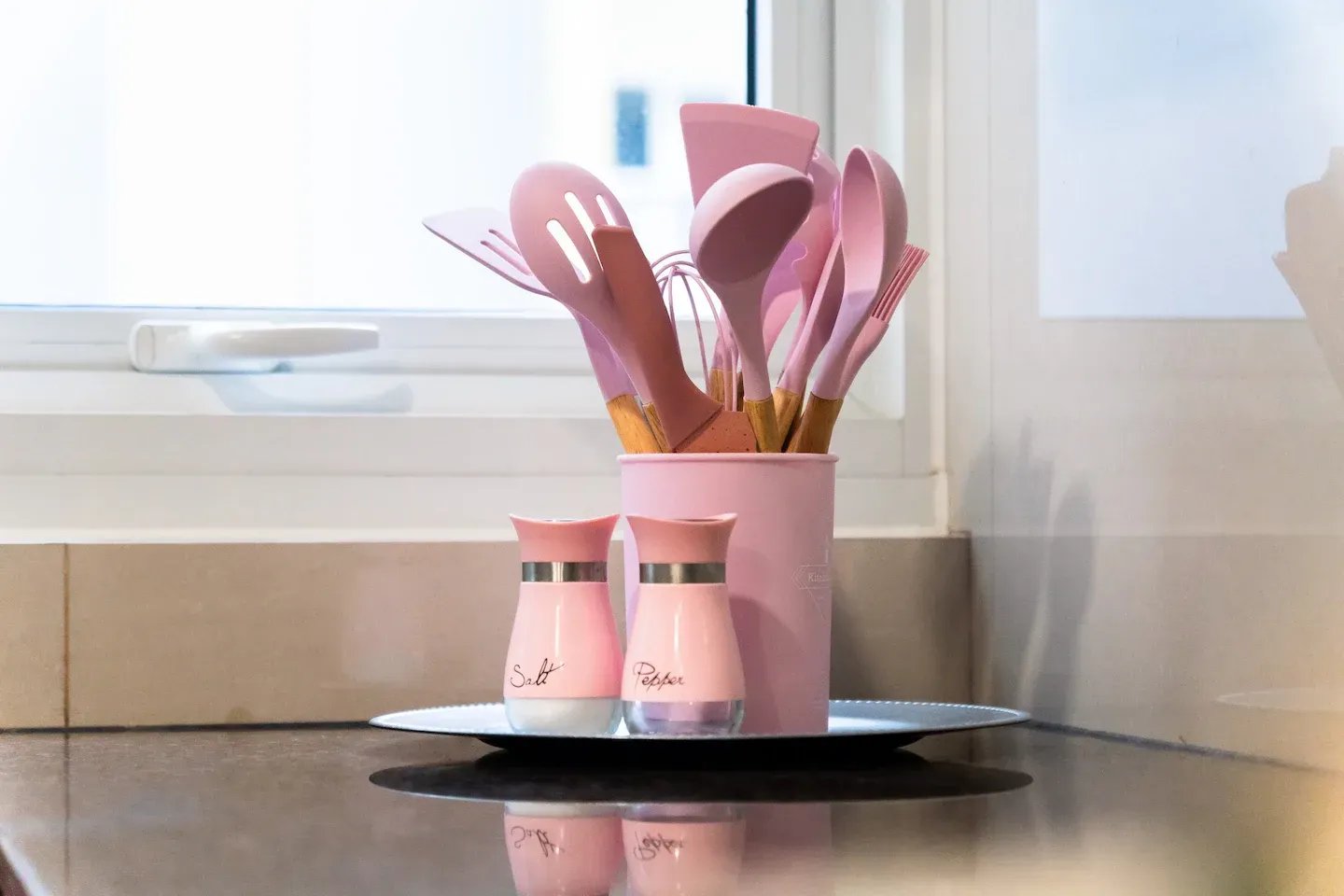 A pink pot filled with pink utensils and salt and pepper shakers on a counter at Bayshore Luxe by Prime, Manila