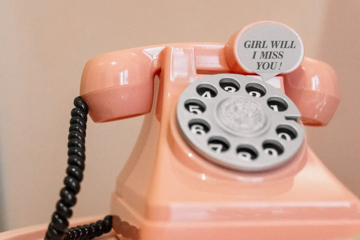 A pink telephone with a speech bubble that says girl will i miss you