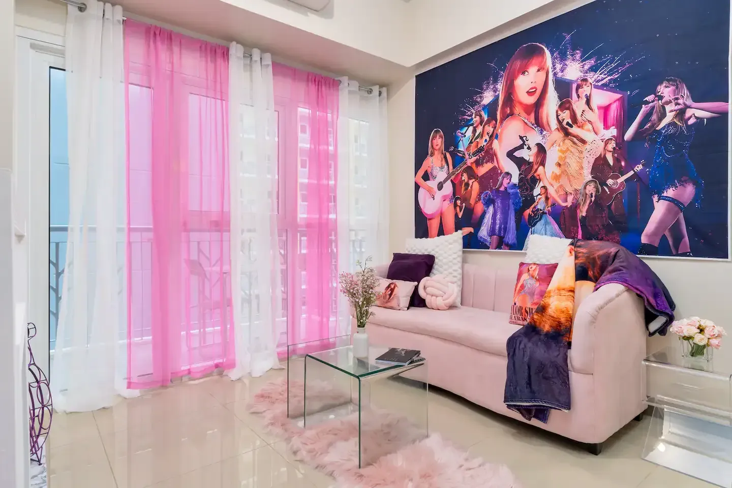A living room with a pink couch , a glass coffee table , and a painting on the wall at Bayshore Luxe by Prime, Manila