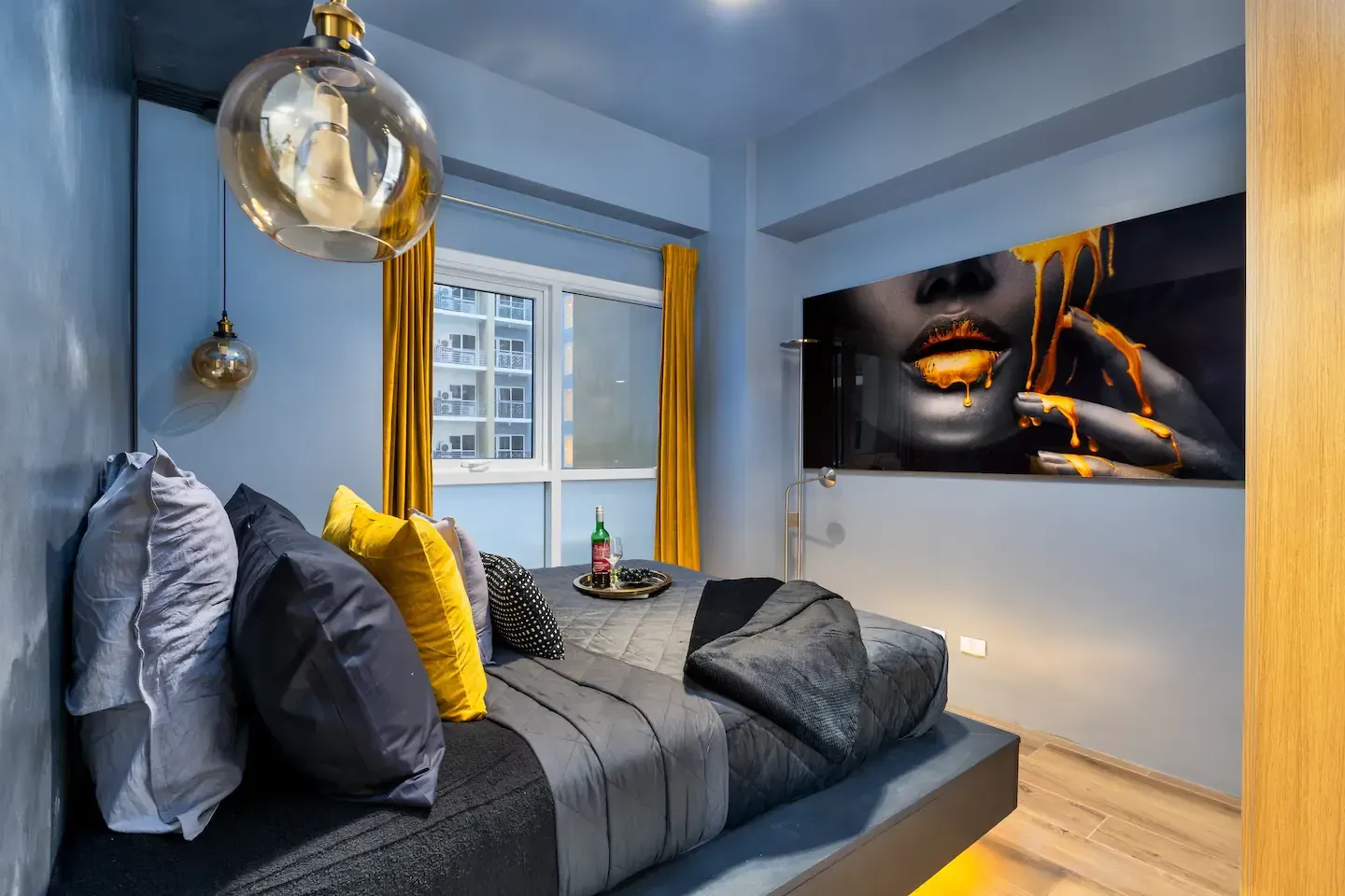 A bedroom with a bed and a painting on the wall.   The Den at Bayshore Luxe by Prime, Manila