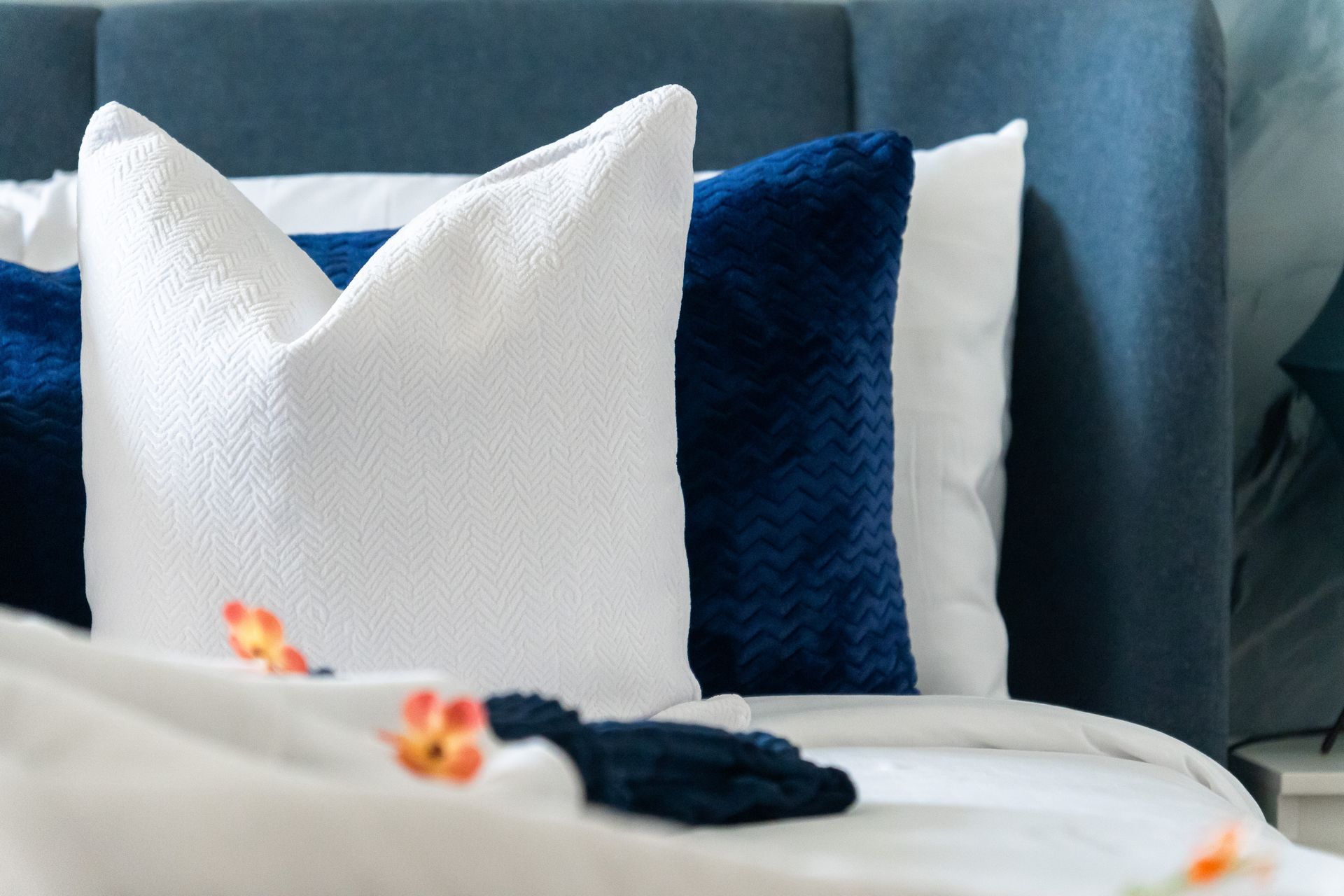 Bed decorated with blue and white pillows and cushions