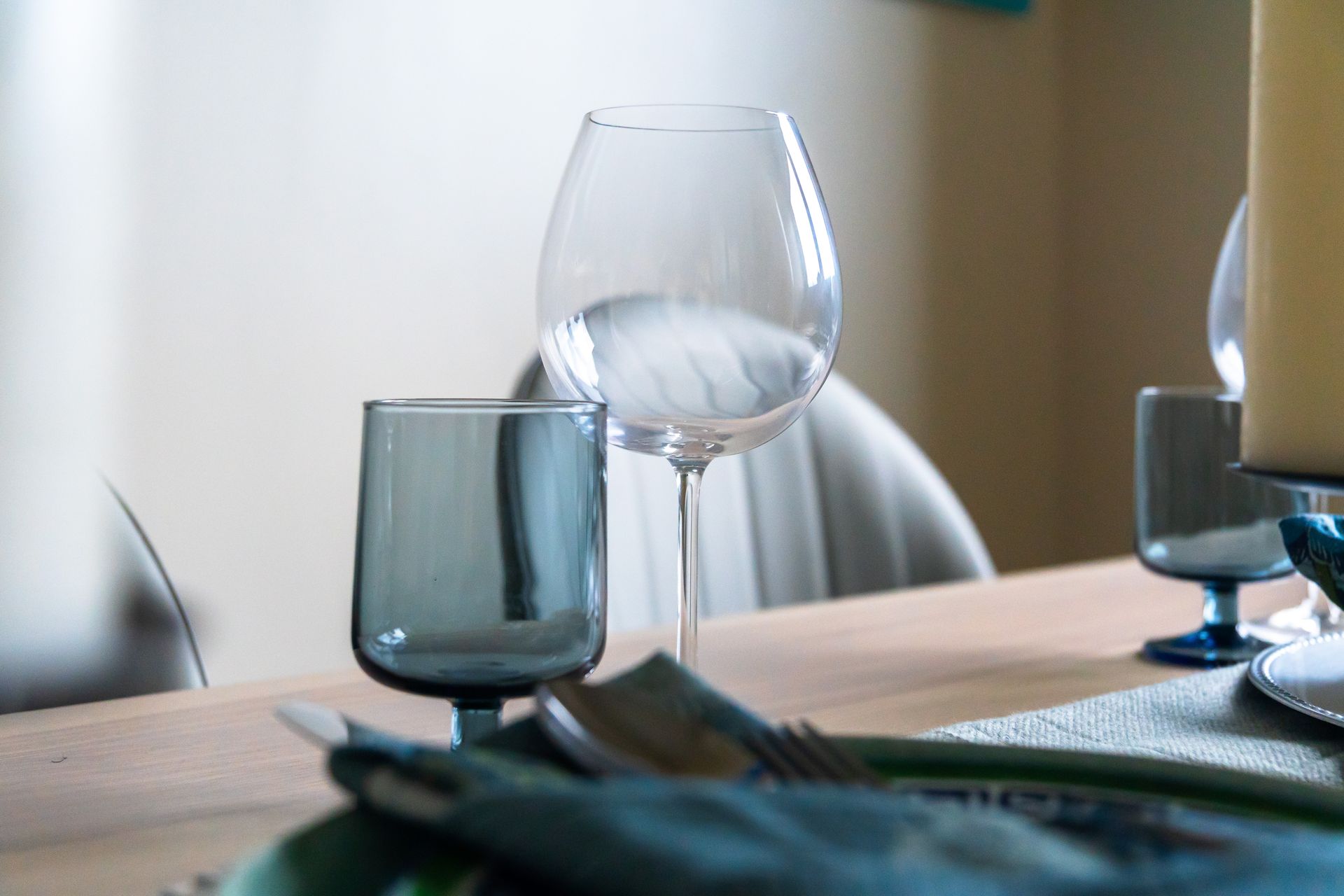 Wine glasses on a white table with blue serviettes 