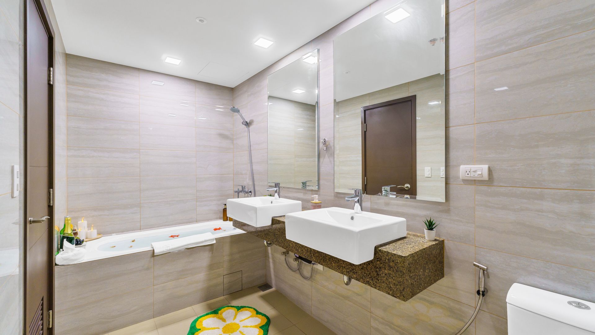 Double bathroom sink counter top with mirrors and a bathtub to the side