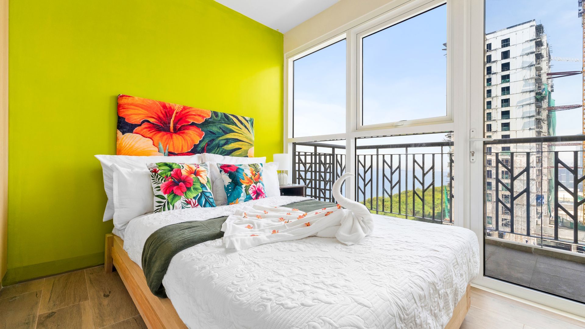 Bed with white linens and tropical cushions 