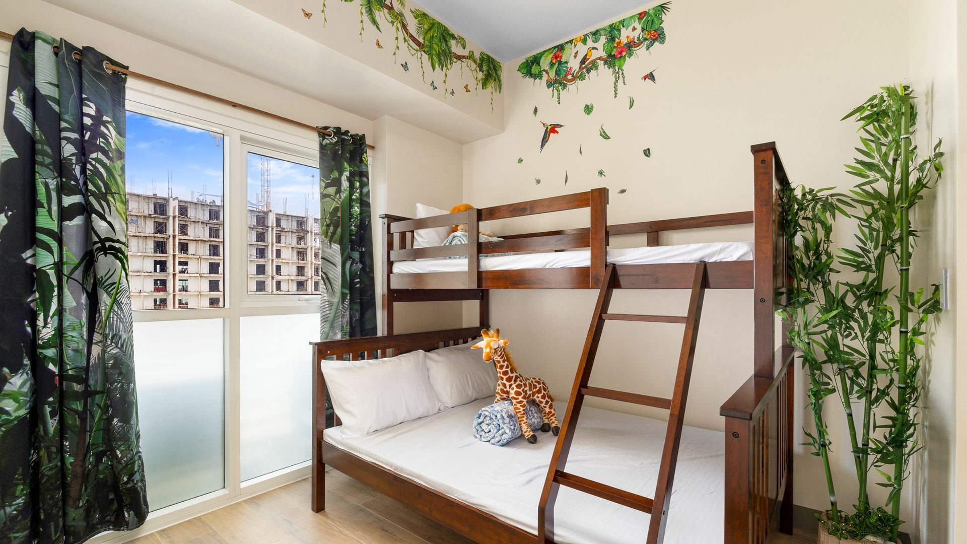 Dark wooden double bunk with single bed above, white linens and jungle detail
