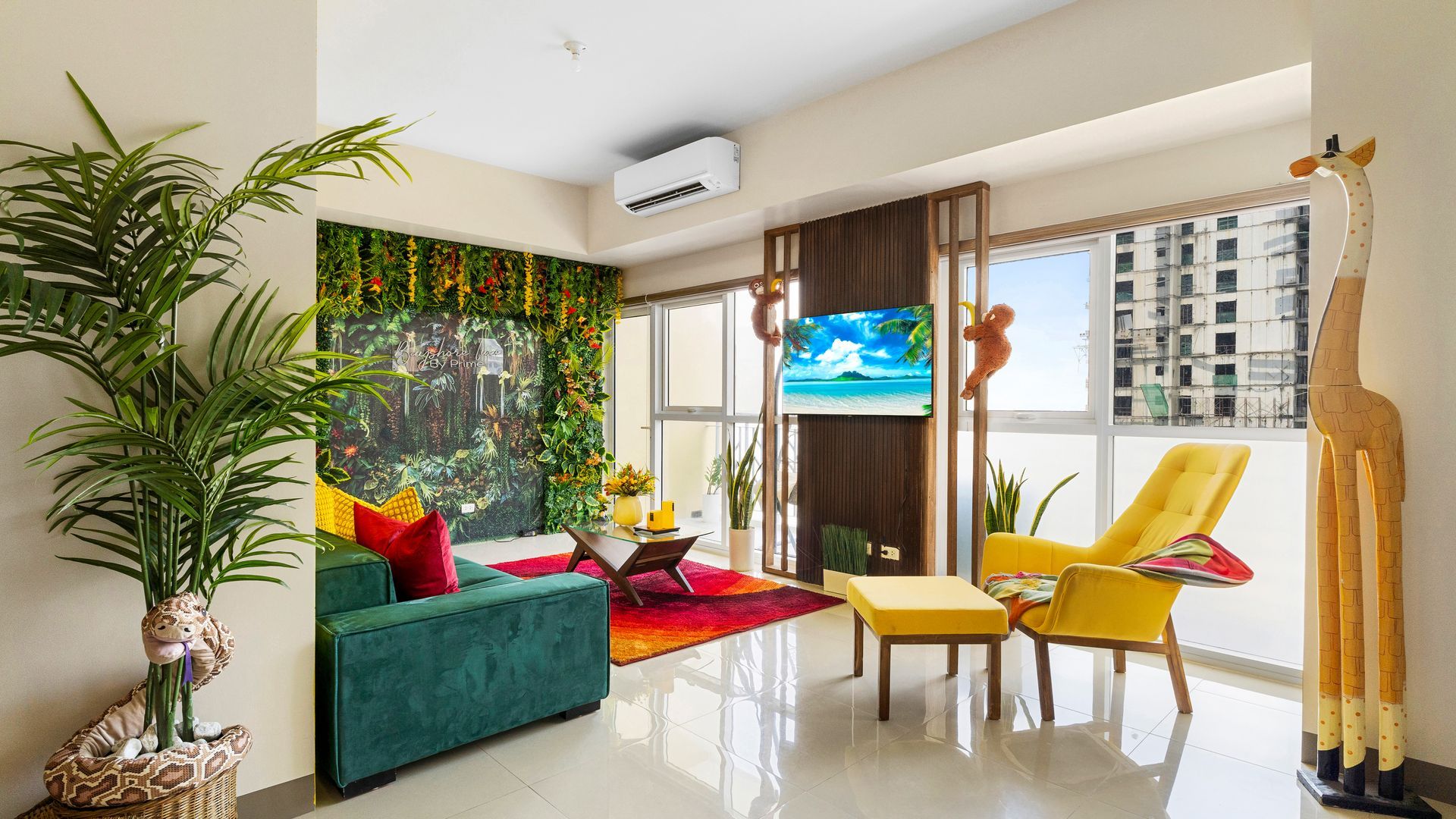 Living room with deep green sofa, yellow armchair, tropical feature wall and TV